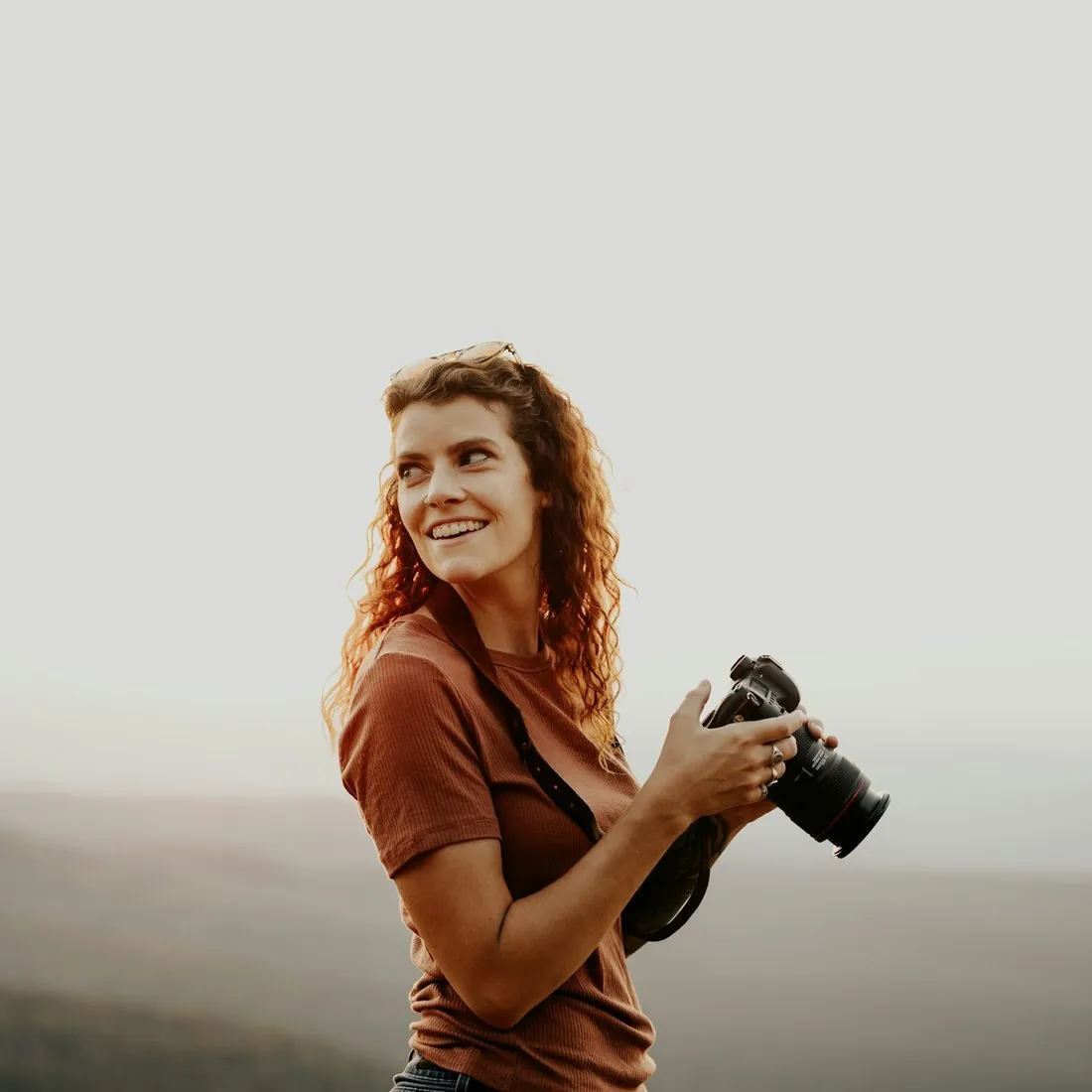 Smiling travel creator holding a camera